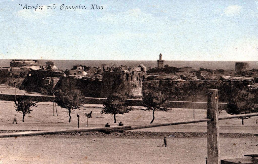 Επιχρωματισμένη Καρτ Ποστάλ. Απεικονίζει την βορειοδυτική πλευρά του Κάστρου της Χίου. Η καρτ ποστάλ είναι σίγουρα πριν το 1920 γιατί φαίνεται ο μικρός προμαχώνας που προφύλασσε τη Επάνω Πορτέλο και διακρίνονται δύο ψηλότερα κτίρια.